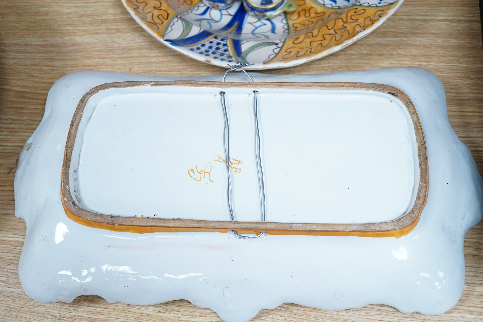 Two 18th century Delft polychrome chargers, five other faience chargers, a rectangular 19th century French faience dish and a blue and white letter rack